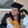 Jacqueline Hernandez Rico, 33, gets a hug from her sons Adan Sebastian Hernandez, 4, and Ivan Santiago Hernandez, 6, while watching the Raza Grad online at her parent's home in Perris on June 13, 2020. (UCR/Stan Lim)